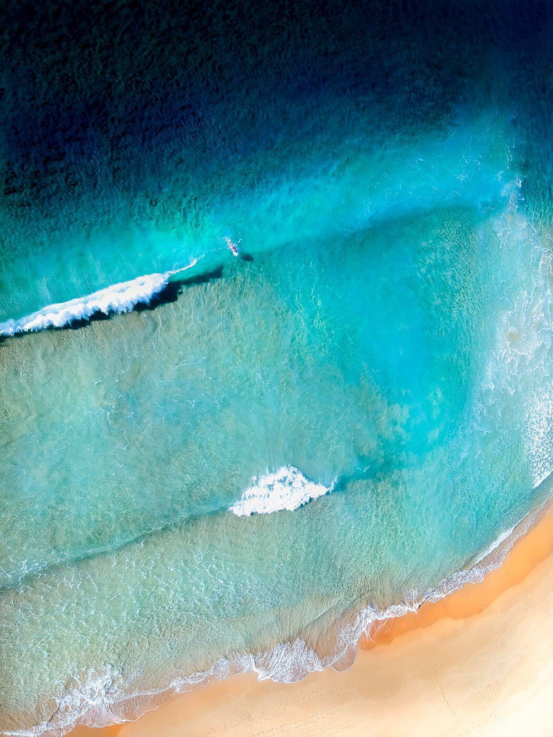 A lone surfer in the waves near the beach